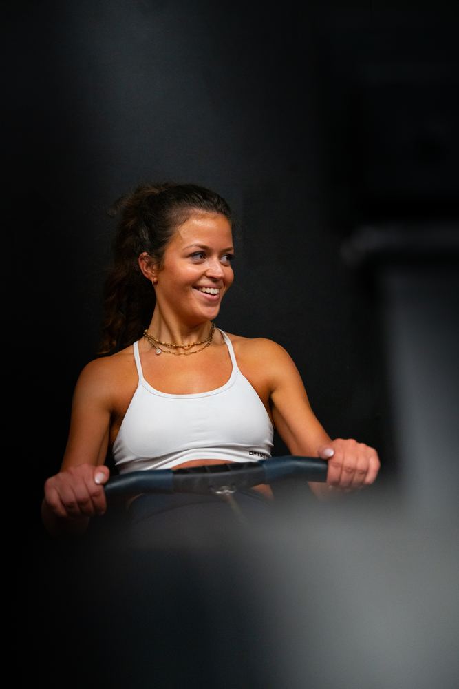 Woman smiling mid-row during a class